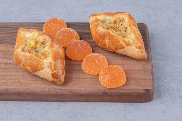 面包在大理石桌上的木板上放两份馅饼和marmelades馅饼土耳其语甜点