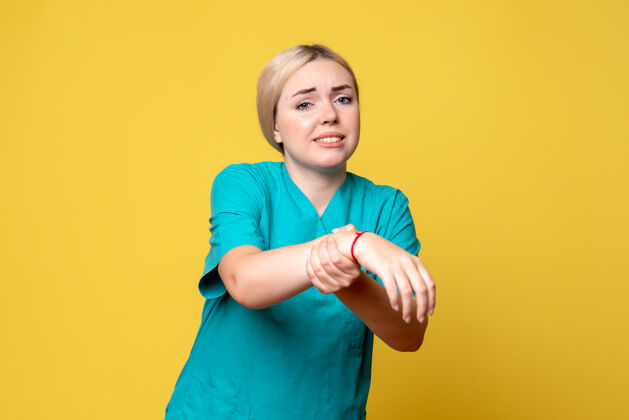 美丽黄墙上年轻女医生穿着医用衬衫 手受伤的正面图肖像快乐医疗