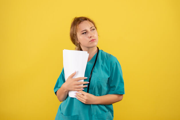前面黄墙上穿着医疗服的女医生手持分析图抱成人肖像