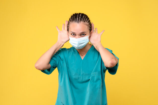 女性正面图：身穿医用衬衫和面罩的女医生 大流行病毒健康医院的彩色护士护士女医生面具