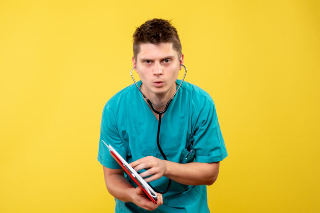 听诊器黄色墙壁上的男医生穿着医疗服 带分析和听诊器男医生医院分析