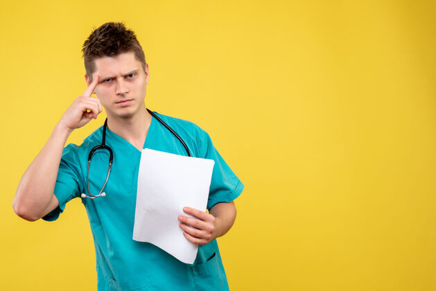 男医生黄色墙壁上的男医生穿着医疗服的正面图听诊器医学肖像