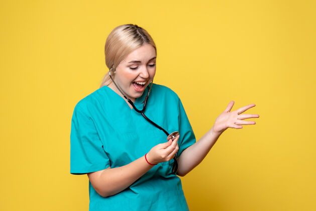 衬衫黄色墙壁上穿着带听诊器的医用衬衫的女医生的正视图前面人医生