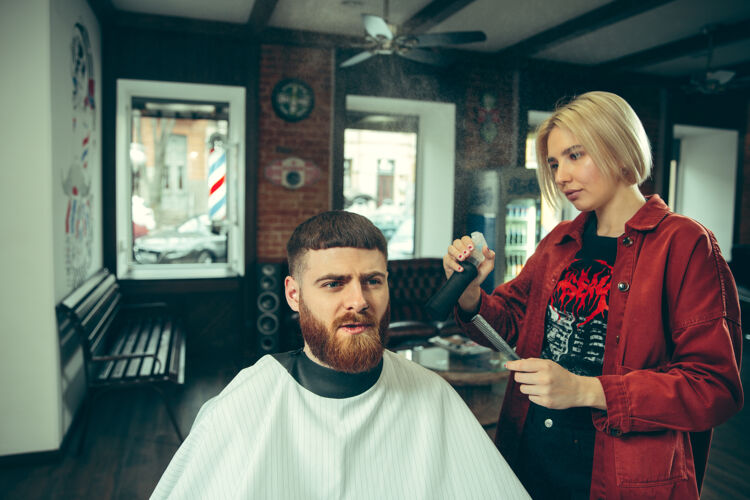 美发师客户在理发店剃须女理发师在沙龙性别平等女性在男性职业剪刀理发师锋利