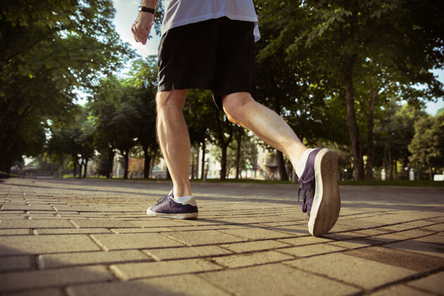 训练高级男子在城市街道上跑步穿着运动鞋的腿部特写镜头高加索男模在夏天的早晨慢跑和有氧训练健康的生活方式 运动 活动理念养老金老年人户外