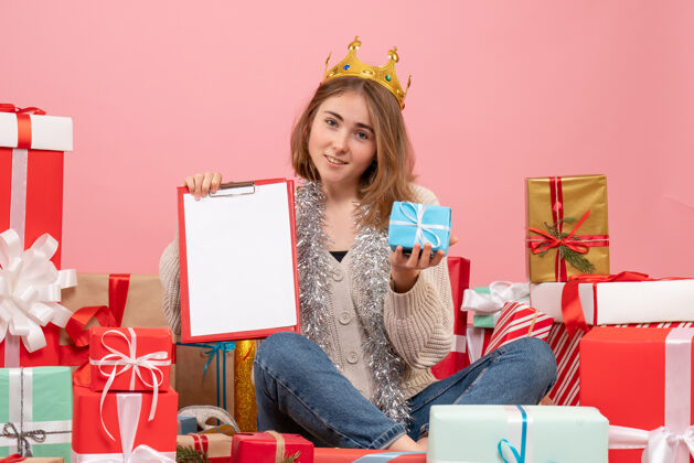 年轻女性正面图年轻女性围坐在礼物旁边 手里拿着纸条礼物情感礼物