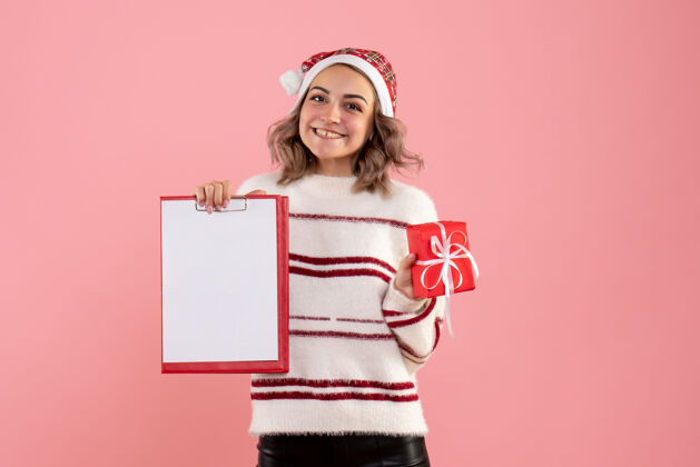 漂亮正面图年轻女性手持圣诞礼物和纸条可爱女人肖像
