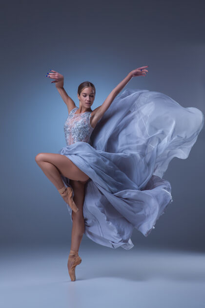 人美丽的芭蕾舞演员在蓝色背景上穿着蓝色长裙跳舞魅力灵感优雅