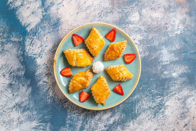 可食用的水果俯瞰美味的甜蛋糕与草莓在蓝色的背景饮食晚餐美味的甜蛋糕