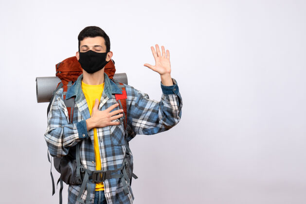 表情正面图男性旅行者带着背包和口罩用手势承诺视图男人工作室