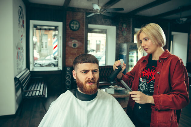 美发师客户在理发店剃须女理发师在沙龙性别平等女性在男性职业剪刀理发师锋利