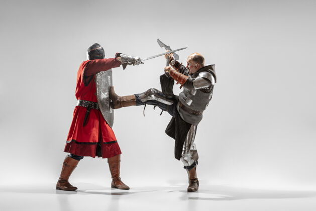 中世纪勇敢的装甲骑士与专业武器战斗隔离在白色工作室背景黑色服装手臂
