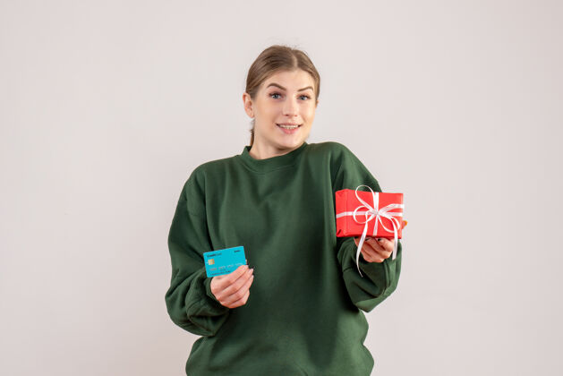 颜色前视图年轻女性 带着小圣诞礼物和银行卡运动衫圣诞节银行