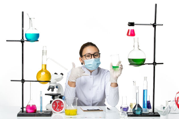 实验室前视图穿着医疗服的女化学家 带面罩 背景为浅白色 飞溅实验室病毒化学covid-解决方案外套病毒