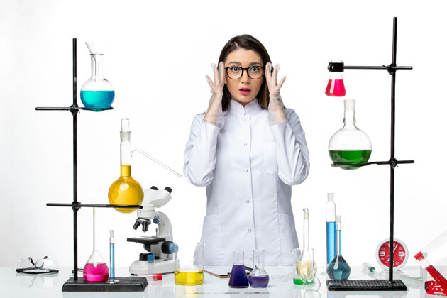 正面正面图：身着无菌医疗服的女化学家站在白色背景上病毒疾病冠状病毒-大流行科学实验室研究大流行