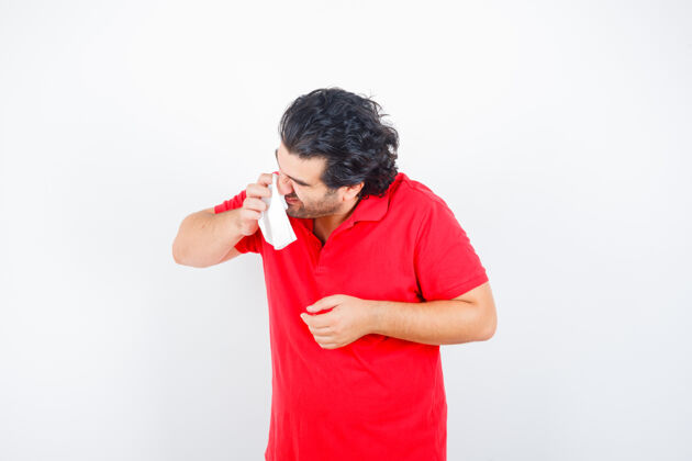 疾病中年男子拿着手帕吹着流鼻涕 穿着红色t恤 看上去不健康 正面照成熟肥胖表情