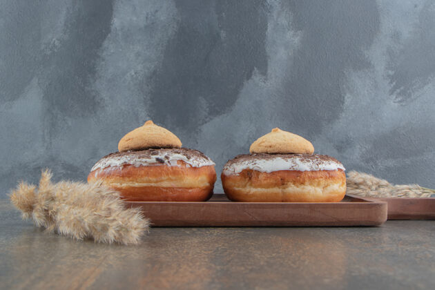美味甜甜圈上的饼干放在木桌上的木板上饼干甜点口感