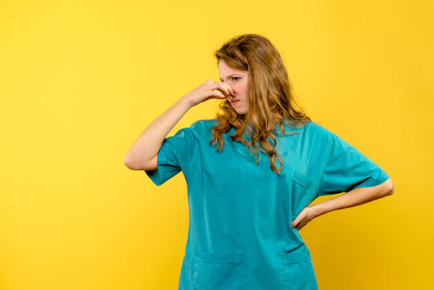 黄色黄墙上女医生鼻塞的正面图可爱医学球衣