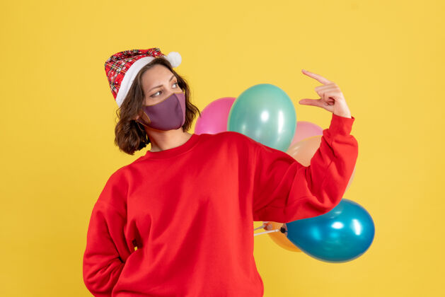 年正面图年轻女性隐藏在无菌面具气球圣诞妇女节日色彩情感新年隐藏乐趣圣诞节