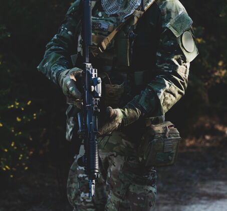 眼镜Airsoft军用游戏玩家 身穿迷彩服 手持突击步枪制服武器手臂