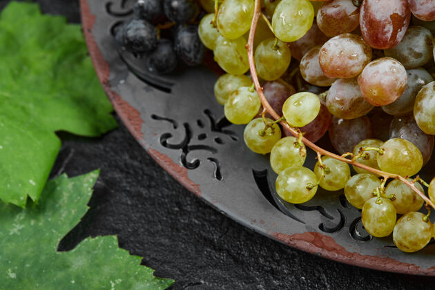 葡萄陶瓷盘子上放着一束混合的葡萄高质量的照片自然食物成熟