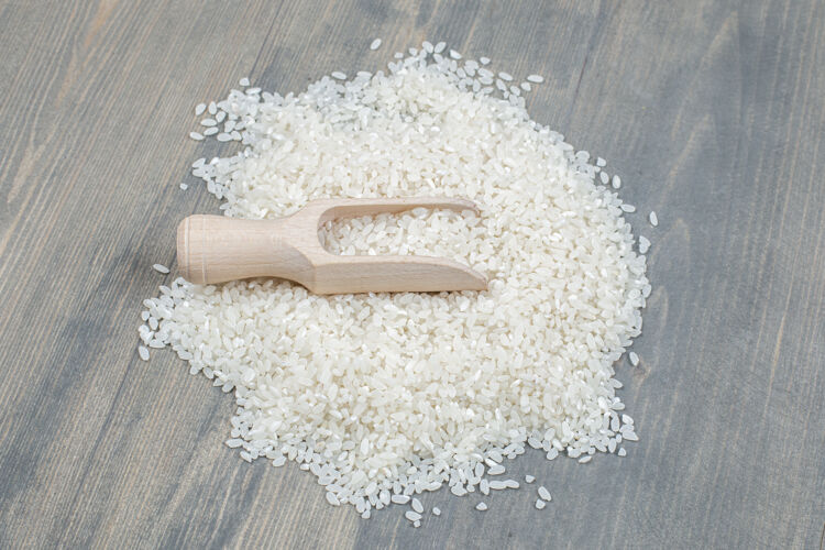 文化健康的生米用木勺放在木桌上大米干的有机