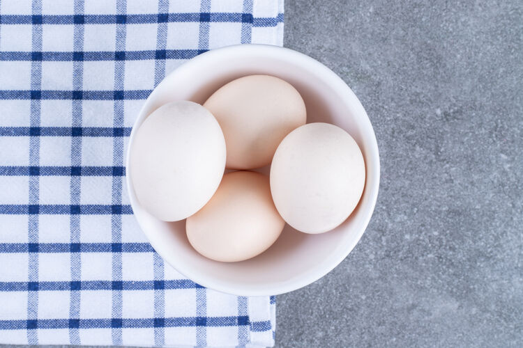 纸箱白盘子里放着新鲜的白鸡蛋烹饪烤肉农业