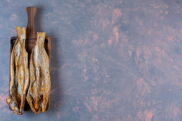 一餐板子上的咸鱼 大理石背景上的海鲜鱼烘焙