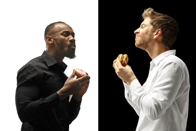 健康在黑白背景下吃汉堡包和甜甜圈的男人快乐的非洲和高加索男人汉堡 快餐 不健康的食物概念人类餐厅简介