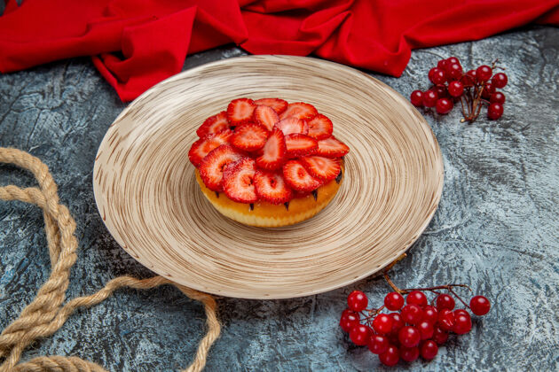 营养正面是美味的草莓蛋糕和红色浆果在黑暗的表面蛋糕水果健康