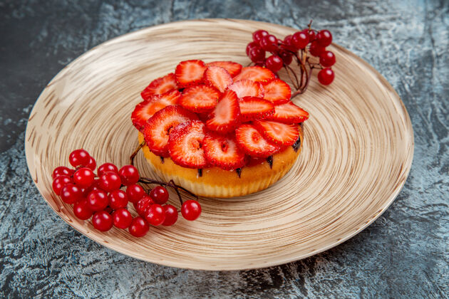 美味正面是美味的草莓蛋糕和红色浆果在黑暗的表面派水果早餐