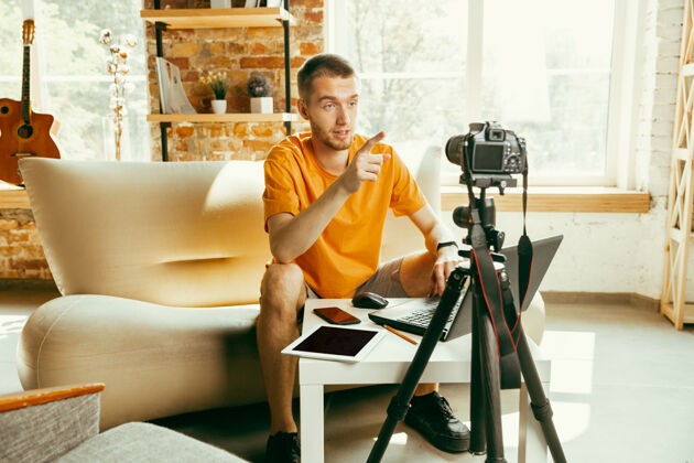 在线年轻的白人男性博主 带着专业的摄像机 对家里的小玩意进行视频评论博客 视频博客 视频博客关于照片或技术新颖性的男人制作视频博客或直播流通信群众测试