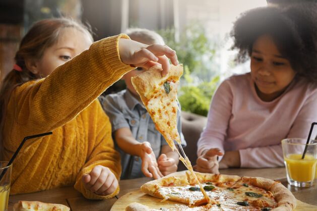 美食中等身材的孩子在吃比萨饼水平美味美味