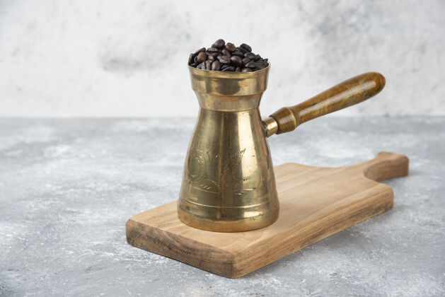 种子装满烤咖啡豆的咖啡壶放在木板上咖啡机美食香味