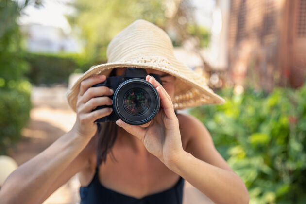 休息炎炎夏日 一位戴帽子的年轻女子用专业单反相机拍照爱好热帽子