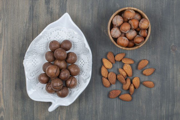 木材健康的澳洲坚果和杏仁放在木桌上营养蛋白质堆