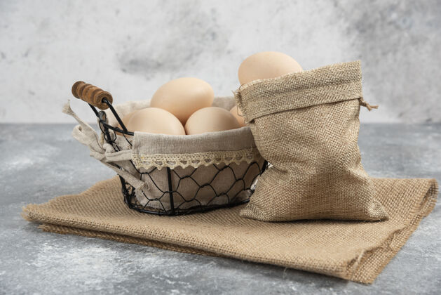 美味篮子和麻布有机新鲜生鸡蛋放在大理石表面鸡鸟鸡蛋