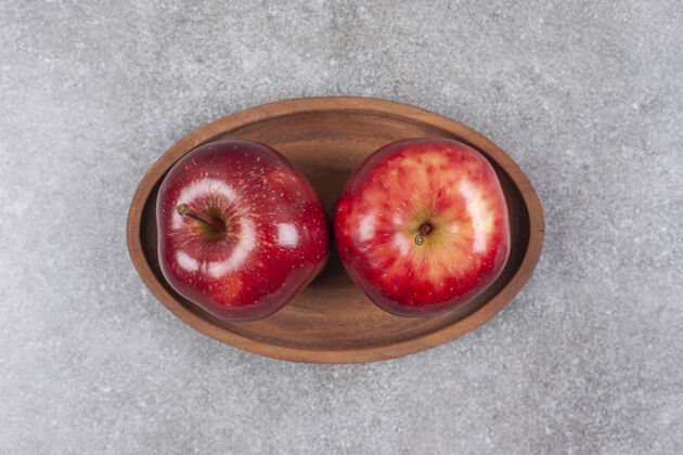 水果木盘上有两个红苹果生的成熟的天然