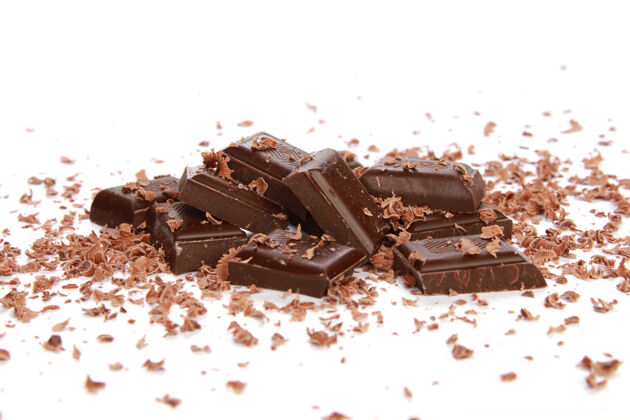 糖果白色表面上的巧克力片和小刨花食物不健康巧克力