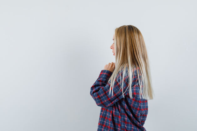 健康金发女人站在祈祷姿势在格子衬衫和寻找重点前视图皮肤肖像脸