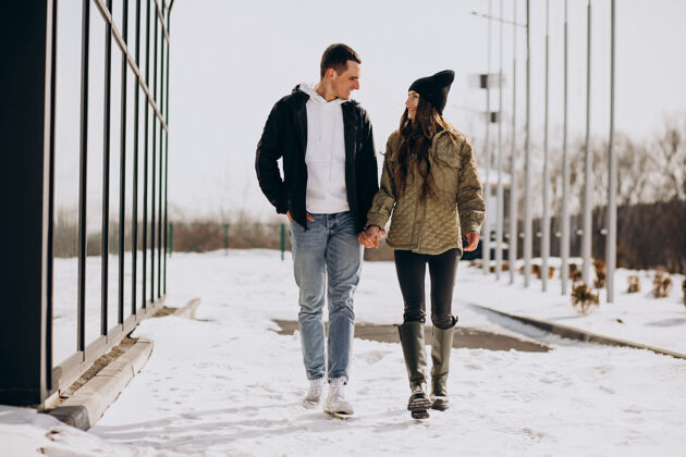 快乐恋爱中的年轻情侣在冬天散步下雪女人好看