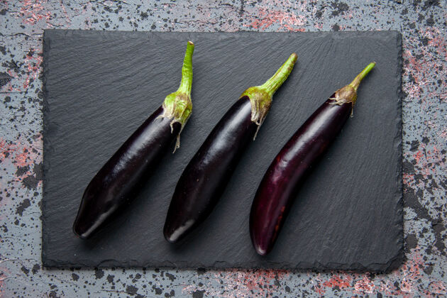 午餐顶视图黑色茄子在砧板上蓝色的表面午餐沙拉成熟的颜色餐食品笔胡椒膳食