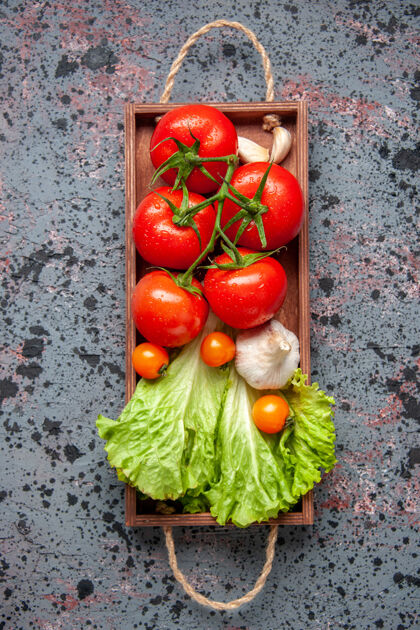 食物顶视图新鲜蔬菜红色西红柿大蒜和绿色沙拉内木板蓝色表面食物颜色午餐沙拉成熟景观蔬菜木头