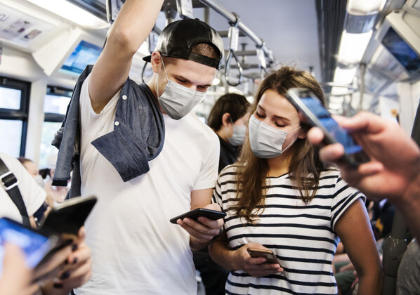 公众新常态下乘坐公交出行时戴口罩的情侣上火车防护女人手机