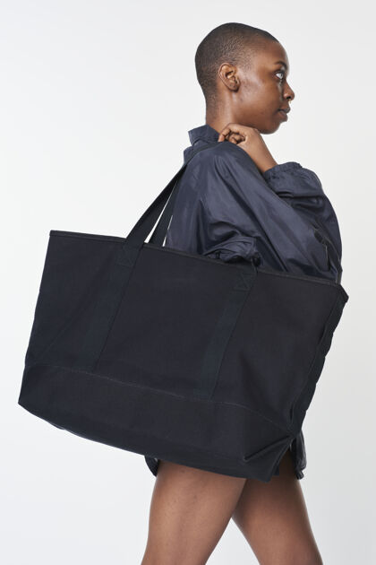 普通黑色女孩带着一个黑色超大的空手提包服装携带模型