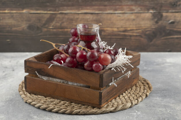 盒子美味的成熟葡萄和一杯装在木箱里的果汁女性小吃美味