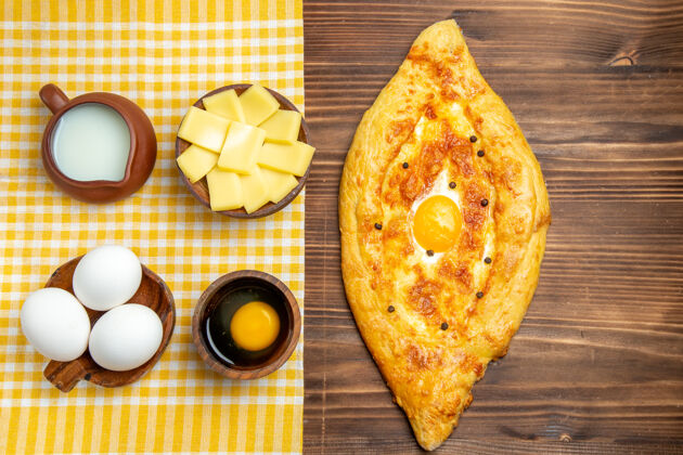 面团顶视图生鸡蛋加奶酪鸡蛋面包和牛奶放在木头表面产品鸡蛋面团餐生食品小吃鸡蛋晚餐