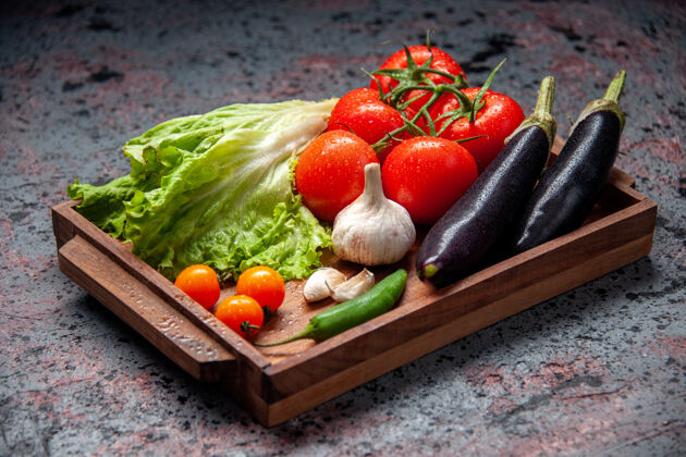 新鲜蔬菜前视图新鲜蔬菜红色西红柿大蒜绿色沙拉和茄子内木板蓝色背景沙拉西红柿饮食
