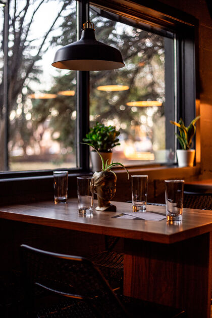 室内棕色木桌上的圆形底座透明酒杯和圆形黑白吊灯室内家具咖啡厅