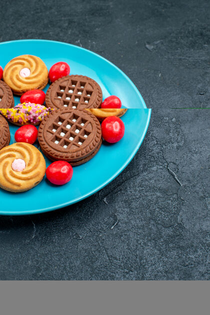新鲜前视图不同的糖饼干与糖果的灰色表面糖果糖甜茶饼干饼干饼干水果草莓饼干